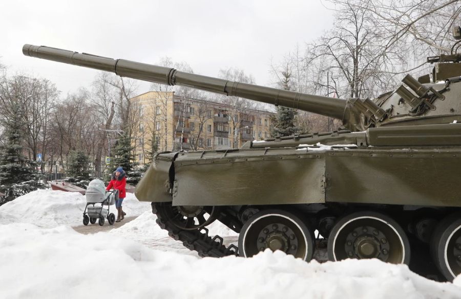 Eine junge Mutter schiebt ihren Kinderwagen in Moskau an einem Panzer vorbei.