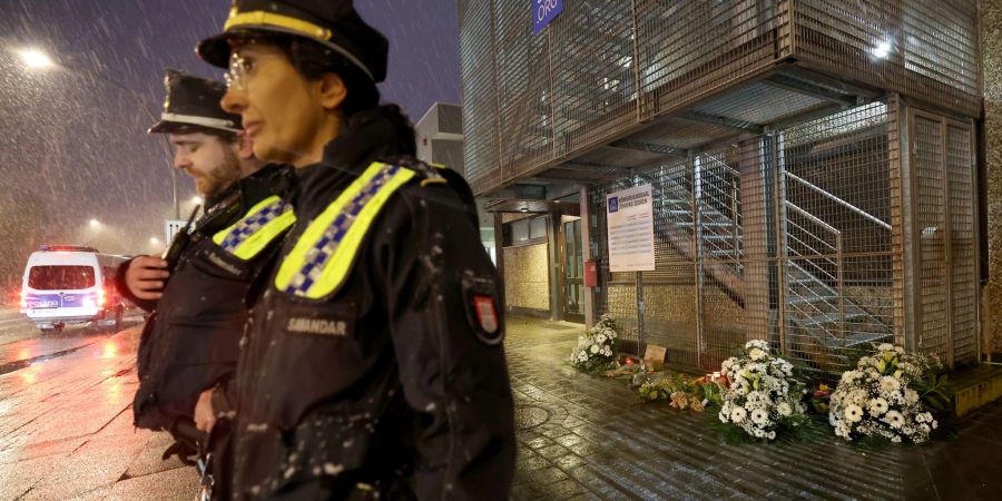 Polizeibeamte stehen im Hamburger Stadtteil Alsterdorf vor dem Gebäude der Zeugen Jehovas, wo ein Amokläufer erst sieben Mensch und dann sich selbst tötete.