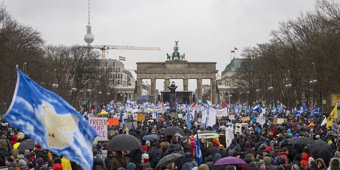 Teilnehmer einer Demonstration für Verhandlungen mit Russland stehen vor dem Brandenburger Tor. Foto: Christophe Gateau/dpa sahra wagenknecht alice schwarzer