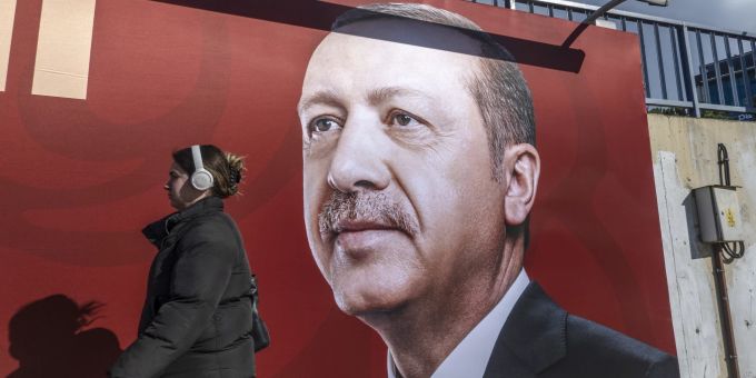Eine Frau läuft vor einem Bild von Präsident Erdogan vorbei. Präsident Erdogan