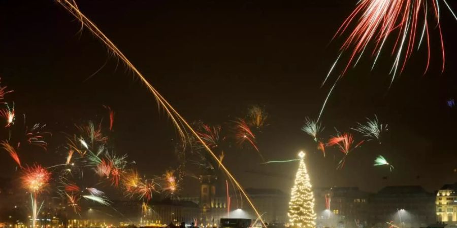 Silvesterraketen erleuchten den Himmel über der Binnenalster in Hamburg. Foto: Angelika Warmuth/dpa/Archiv