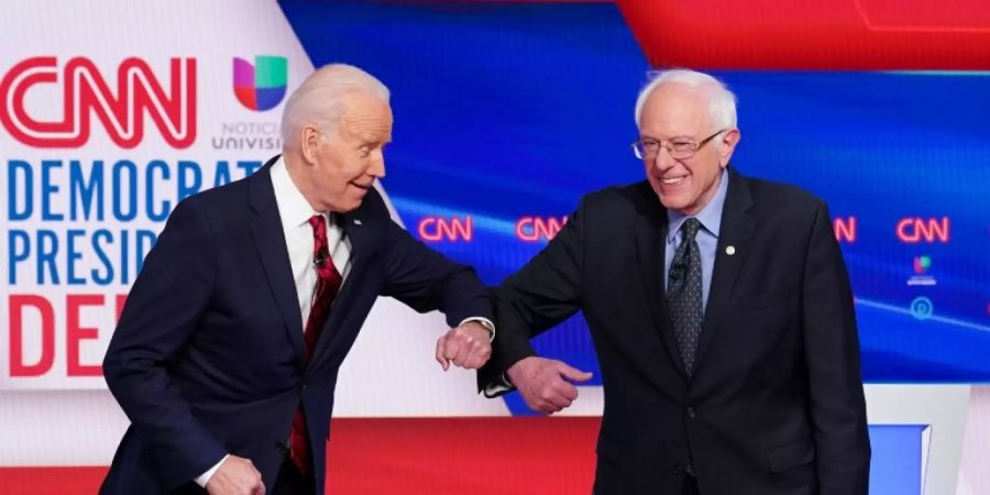 Die Präsidentschaftsbewerber Biden (l.) und Sanders begrüssen sich mit dem Ellenbogen