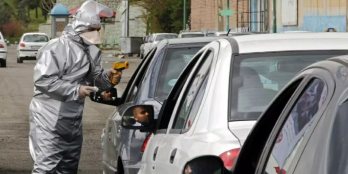 Ein Mitarbeiter des iranischen Roten Kreuzes bei einer Fieberkontrolle Ein Mitarbeiter des iranischen Roten Kreuzes bei einer Fieberkontrolle