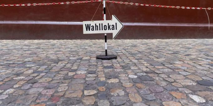 Ein Pfeil zeigt in Richtung eine Wahllokals. Wahllokal