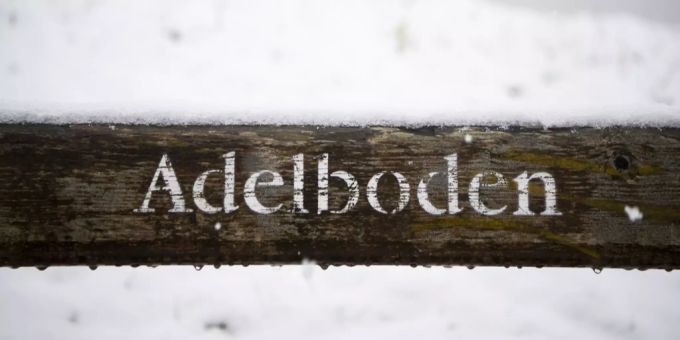 Adelboden steht auf einer Bank. Adelboden