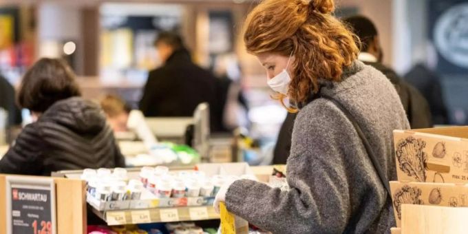 Sicher ist sicher: Mit einer Schutzmaske kauft eine Frau in einem Supermarkt ein. Foto: Peter Steffen/dpa coronavirus