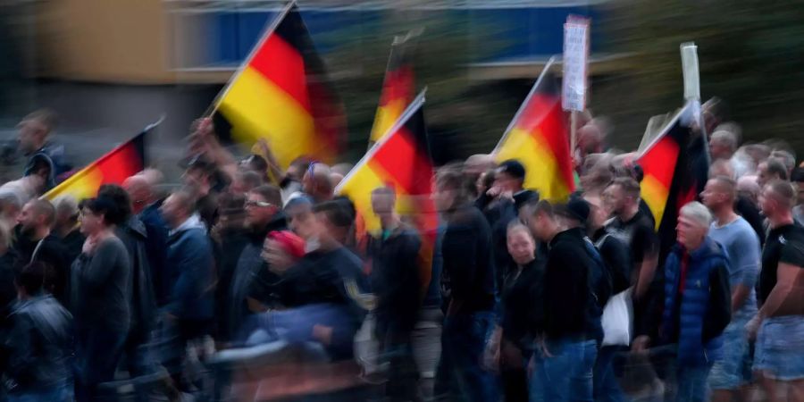 Mit Deutschland-Fahnen ziehen Demonstrationsteilnehmer durch die Chemnitzer Innenstadt.