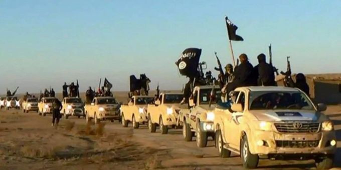 Eine Karawane von Autos fahren in Syrien. Auf den Ladeflächen stehen Dutzende IS-Kämpfer die Fahnen und Waffen hochstrecken. Eine Karawane von Autos fahren in Syrien. Auf den Ladeflächen stehen Dutzende IS-Kämpfer die Fahnen und Waffen hochstrecken.