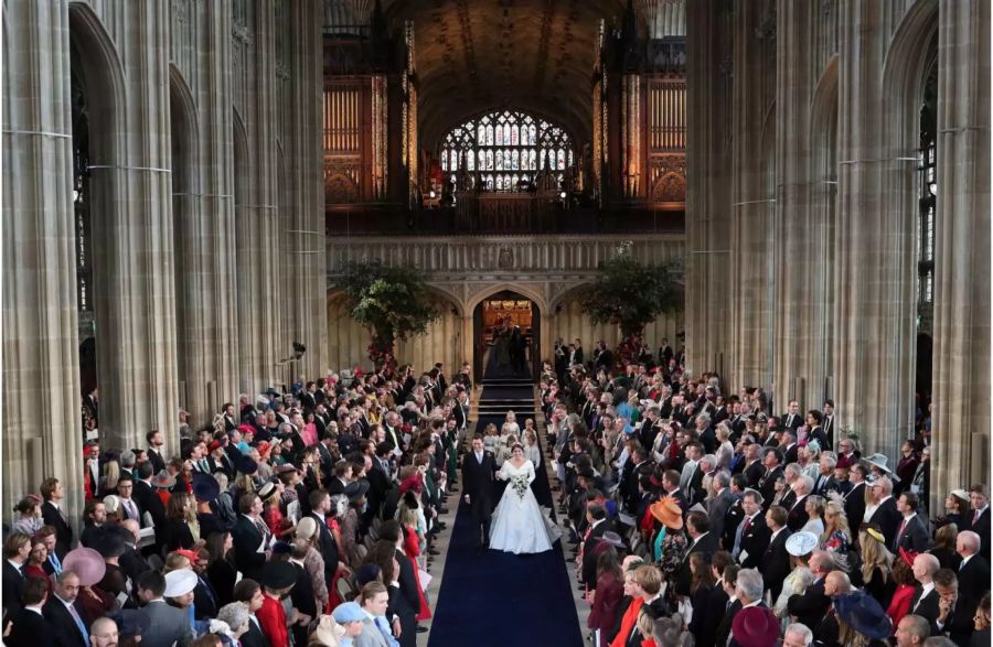 Das Brautpaar läuft zusammen zum Altar.