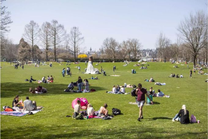 Leute liegen auf einer Wiese in Luzern im April 2018 - Keystone Leute liegen auf einer Wiese in Luzern im April 2018 - Keystone