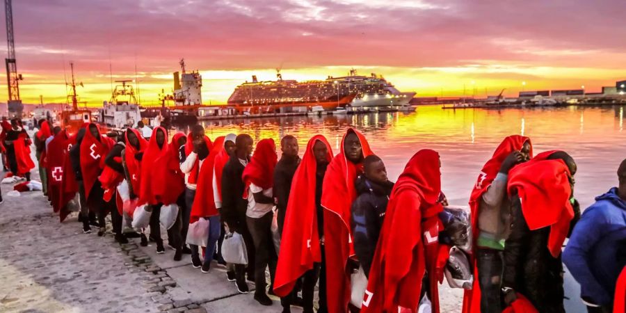 Einwanderer aus Nordafrika stehen am Hafen von Malaga.