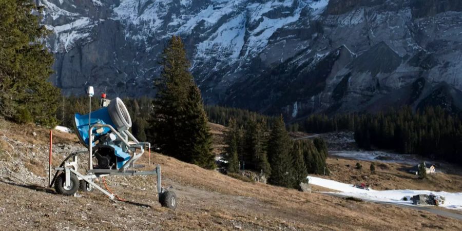 Eine Schneekanone auf brauner Wiese ohne Schnee. Aufgenommen in Kandersteg im Dezember 2016.