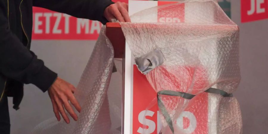 Das Rednerpult wird auf der SPD-Wahlparty beim Abbau der Bühne mit Plastikfolie verpackt.