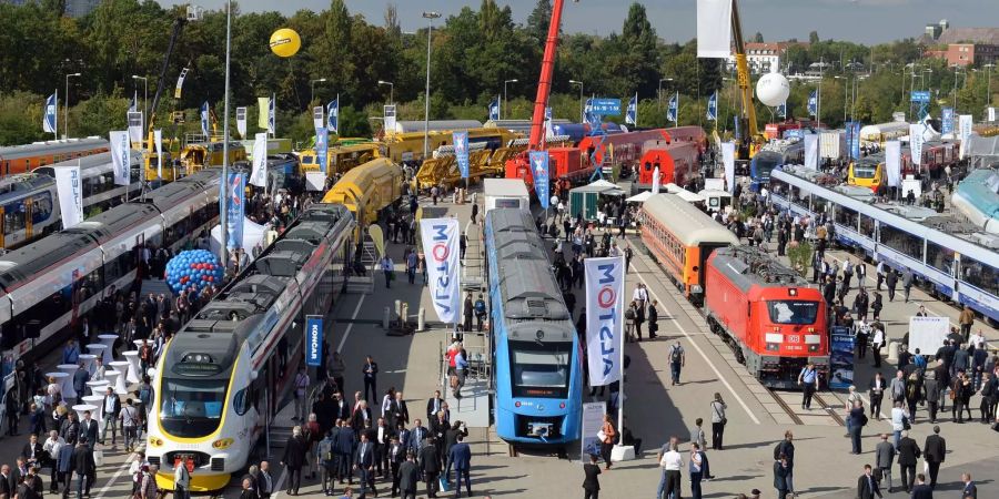 Besucher gehen bei Bahntechnikmesse InnoTrans über die Ausstellungsfläche in Berlin.