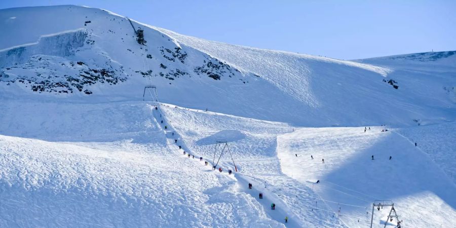 Menschen auf der Piste und auf dem Skilift.