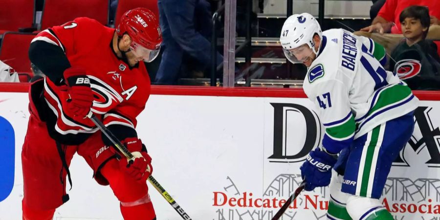 Sven Bärtschi (rechts, Vanouver Canucks) fightet mit Jordan Staal (Carolina Hurricanes) um den Puck.