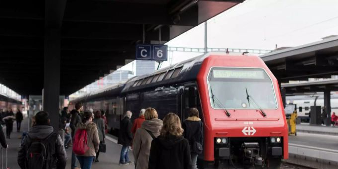 Reisende steigen in einen Zug ein. sbb