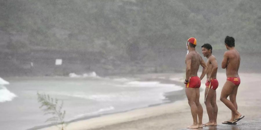 Japan, Katsuura: Rettungsschwimmer beobachten an einem Strand, nachdem das Schwimmen wegen des Taifuns Jongdari verboten wurde.