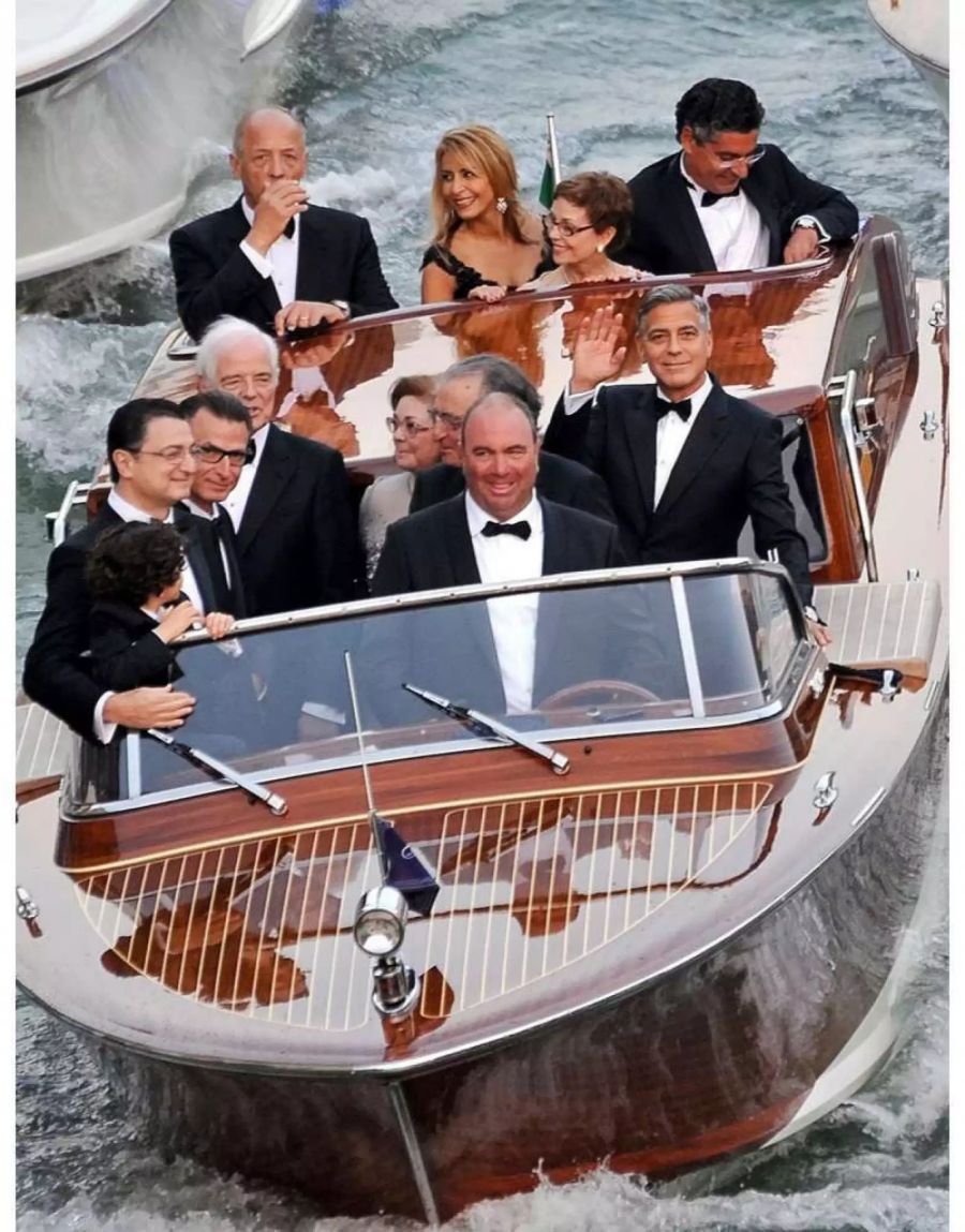 George Clooney (rechts) fährt mit seinen Verwandten und Bekannten auf einem Boot in Venedig: Ramzi Alamuddin (dritter von rechts, vordere Reihe), Nick Clooney (fünfter von rechts, vorderste Reihe) und Nina Warren (zweite von rechts, hinterste Reihe).