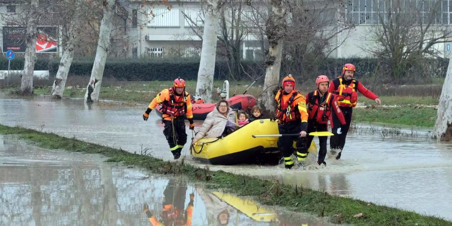 Feuerwehrmänner bringen Bewohner aus Lentigione (Italien) in Sicherheit.