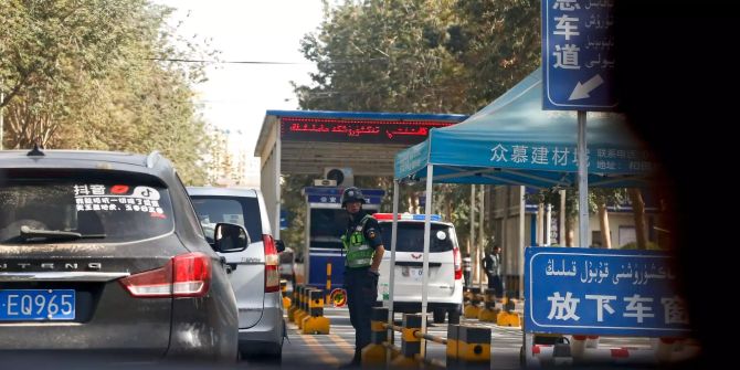 Ein Chinesischer Polizist kontrolliert Autos.