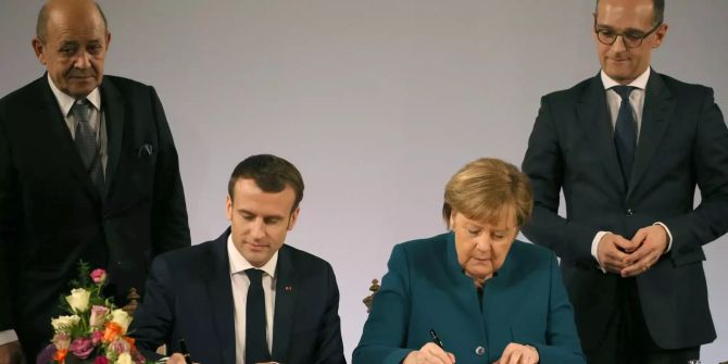 Macon und Merkel unterzeichnen den Freundschaftsvertrag.