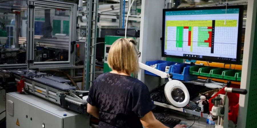 Frau arbeitet an Computer in Elektrik-Fabrik