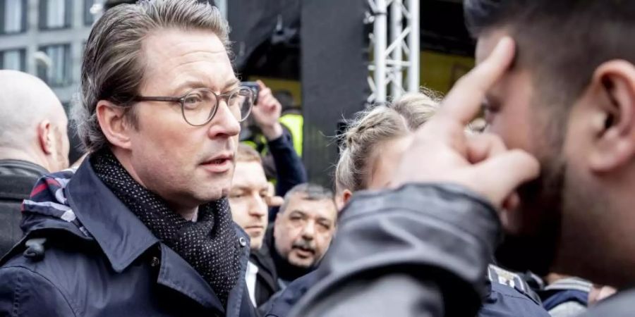 Andreas Scheuer (CSU), Bundesverkehrsminister, unterhält sich bei einer Kundgebung von Taxifahrern am Bundesverkehrsministerium mit einem Teilnehmer. Foto: Christoph Soeder