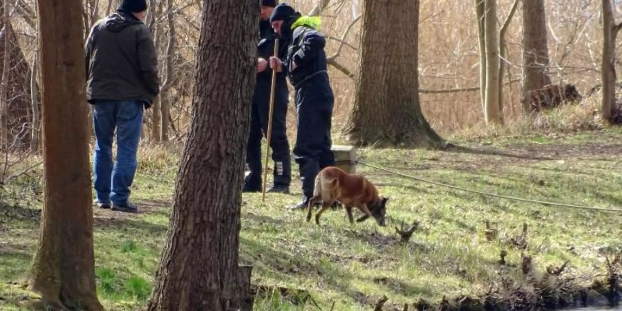 Polizeibeamte mit einem Spürhund suchen am Ufer des Storkower Kanals nahe dem Wolziger See im Landkreis Dahme-Spreewald nach der vermissten Rebecca. Foto: Toni Feist/dpa-Zentralbild