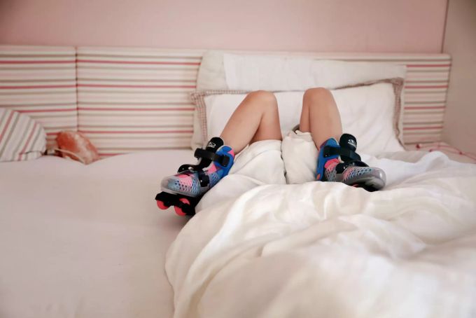 Verwächst sich das? Ab dem achten Lebensjahr korrigieren sich Fachleuten zufolge X-Bein-Fehlstellungen in der Regel nicht mehr von selbst. Kind liegt im Bett.