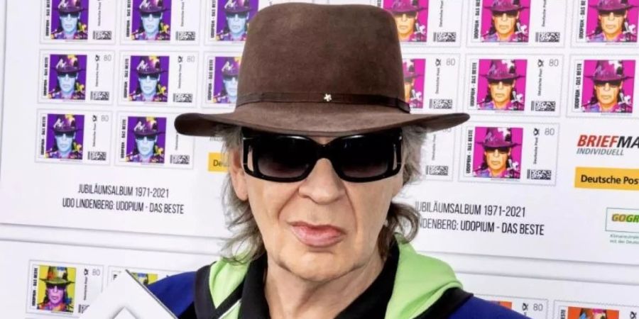 Rockmusiker Udo Lindenberg zeigt einen Ausdruck seiner Sonderbriefmarken, die für einen guten Zweck versteigert werden. Foto: Tine Acke/lanz-unlimited communications/dpa