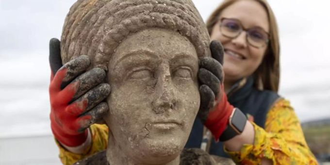 Eine Archäologin hält den Kopf einer römischen Statue, die bei den Ausgrabungen in der St. Mary's Church entdeckt wurde. Foto: Hs2/PA Media/dpa Eine Archäologin hält den Kopf einer römischen Statue, die bei den Ausgrabungen in der St. Mary's Church entdeckt wurde. Foto: Hs2/PA Media/dpa