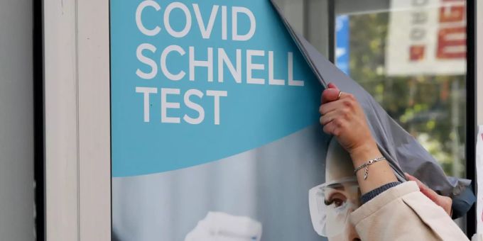 Ein Plakat mit Werbung für Corona-Schnelltests wird abgenommen. Coronavirus-Test