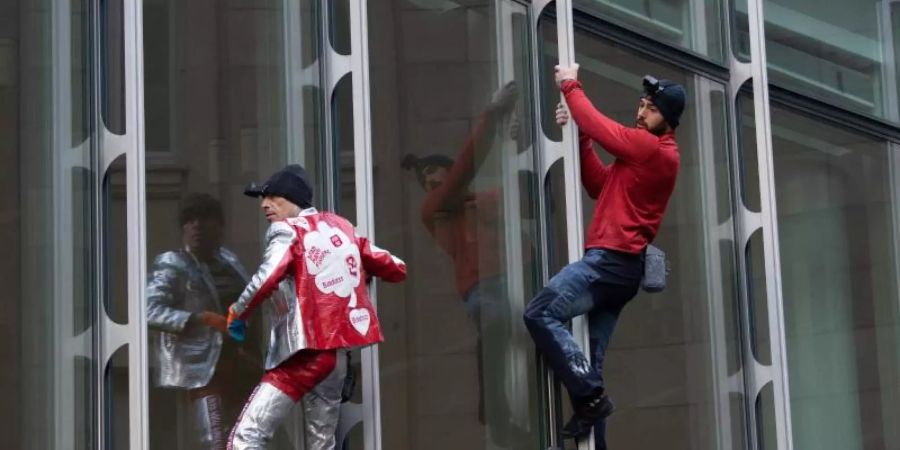 Die beiden Extremkletterer Leo Urban (r) und Alain Robert kletterten ohne jede Sicherung an der Fassade des Skyper-Hochhauses in Frankfurt am Main hinauf. Foto: Boris Roessler/dpa