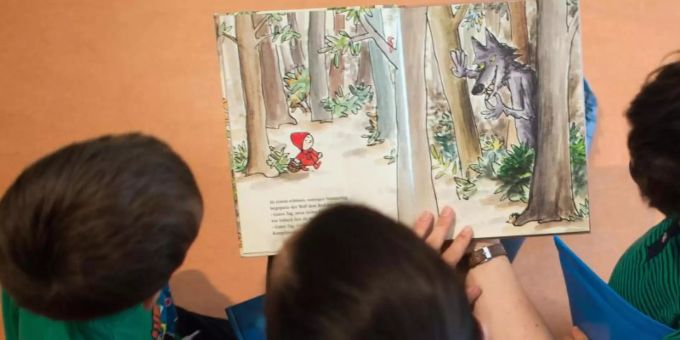 Eine Frau liest Kindern aus einem Buch vor. Foto: Arno Burgi/dpa-Zentralbild/dpa Eine Frau liest Kindern aus einem Buch vor. Foto: Arno Burgi/dpa-Zentralbild/dpa