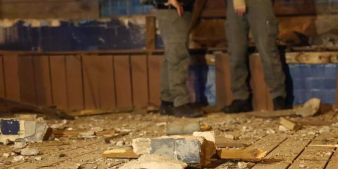Isreaelische Polizisten stehen nach einem Raketenangriff aus dem Gazastreifen neben einer beschädigten Mauer. Foto: Ilia Yefimovich/dpa/Archiv israel