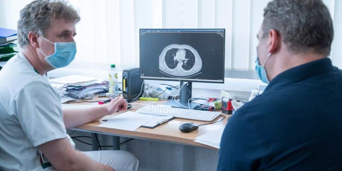 Torsten Blum (l), Lungenfacharzt, zeigt Dimitri Boulgakov, Covid 19 Patient, im Helios Emil von Behring Klinikum auf einer Computertomographie die Spuren, die die Covid 19 Erkrankung in der Lunge hinterlassen hat. Der Facharzt untersucht die Spätfolgen von Patienten, die an Covid 19 erkrankt sind. Spätfolgen Coronavirus Erkrankung
