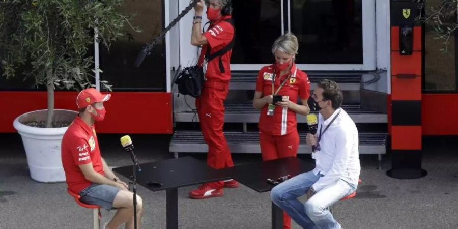 Sebastian Vettel (l) von der Scuderia Ferrari wird auf der Rennstrecke von Mugello interviewt. Foto: Luca Bruno/AP/dpa