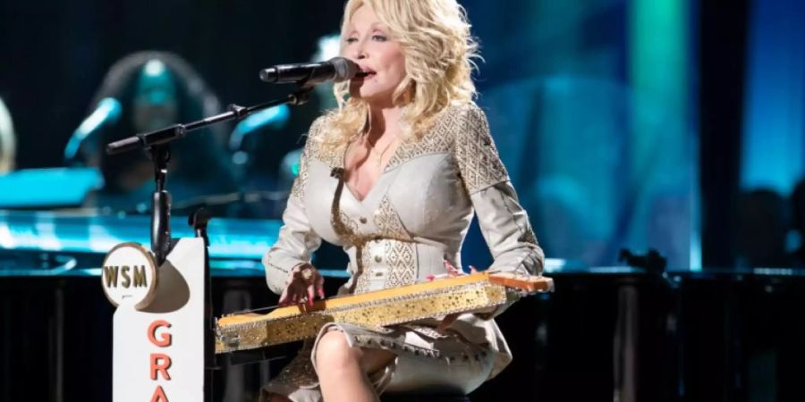 HANDOUT - Dolly Parton, Country-Musikerin, spielt während eines Konzerts auf einer Zither. Eine kristallbesetzte Zither von Country-Ikone Dolly Parton (74) soll in den USA versteigert werden. Foto: Chris Hollo/Grand Ole Opry/Christie's Auction/dpa