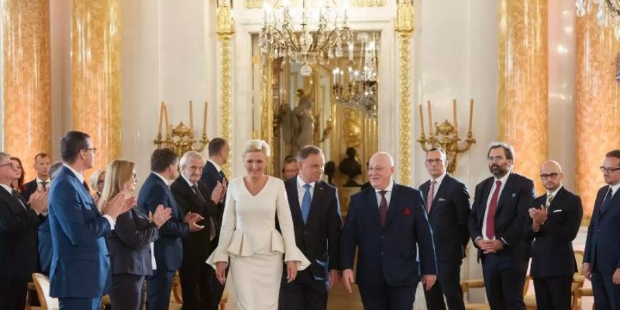 Andrzej Duda (M,r), Präsident von Polen, und seine Frau Agata Kornhauser-Duda (M,l), im Königlichen Schloss zur Übergabezeremonie nach der Präsidentenwahl. Foto: Hubert Mathis/ZUMA Wire/dpa