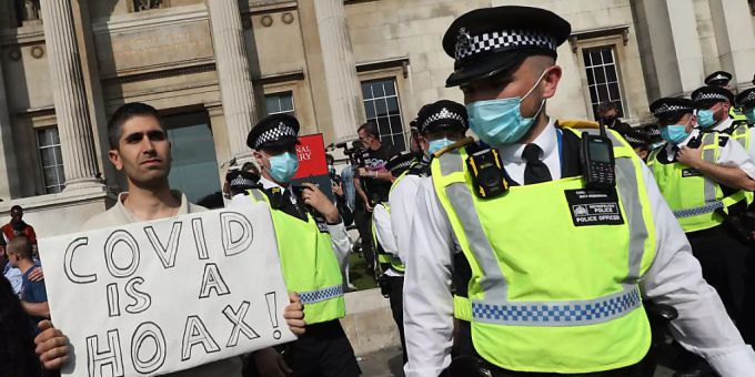 Ein Mann hält am Trafalgar Square bei einer Demonstration von Impfgegnern ein Schild mit der Aufschrift «Covid is a hoax» (Covid ist ein Schwindel) in die Höhe. Foto: Yui Mok/PA Wire/dpa Ein Mann hält am Trafalgar Square bei einer Demonstration von Impfgegnern ein Schild mit der Aufschrift «Covid is a hoax» (Covid ist ein Schwindel) in die Höhe. Foto: Yui Mok/PA Wire/dpa
