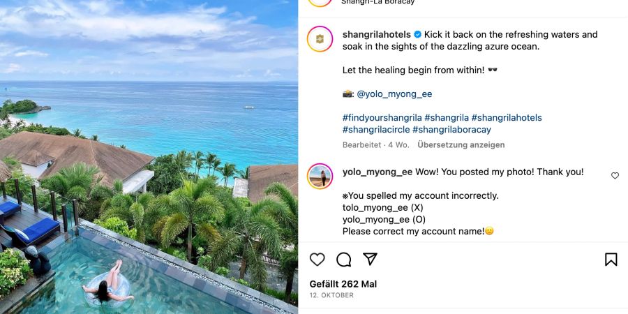 Frau in einem Schwimmreifen im Pool von oben umgeben von tropischen Pflanzen, mit Blick auf das Meer.