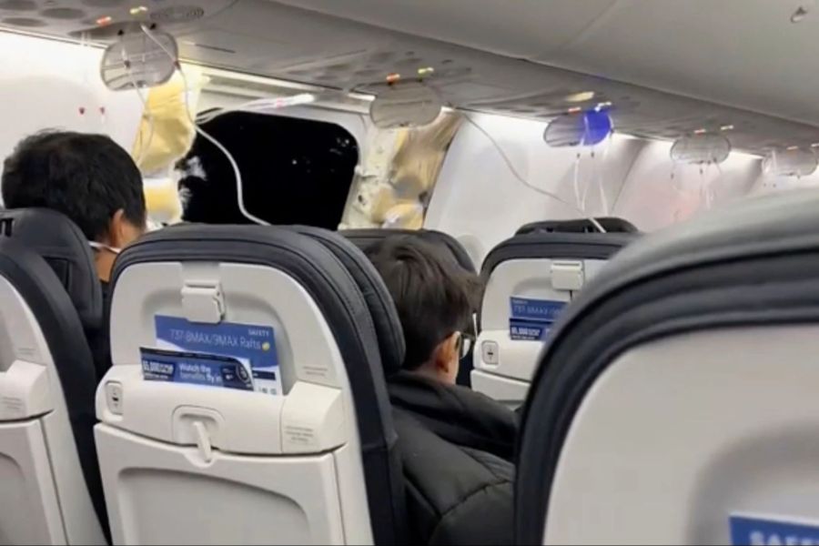 Passagiere sitzen in der Boeing 737 Max 9 in der Nähe des abgerissenen Kabinenteils samt Fenster.