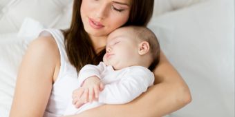 Mutter mit schlafendem Baby auf dem Arm