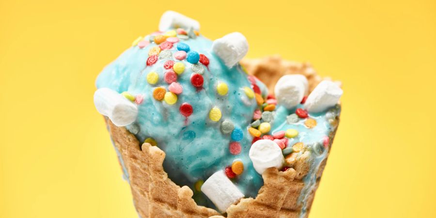 blaue eiscreme, dekoriert mit marshmallows, gelber hintergrund