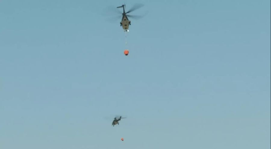 Zwei Armeehelikopter beim Löschen der Brände.