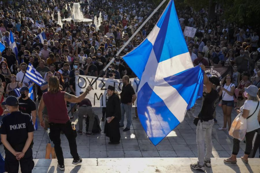 Impfgegner schwingen während eines Protests die griechische Flagge.