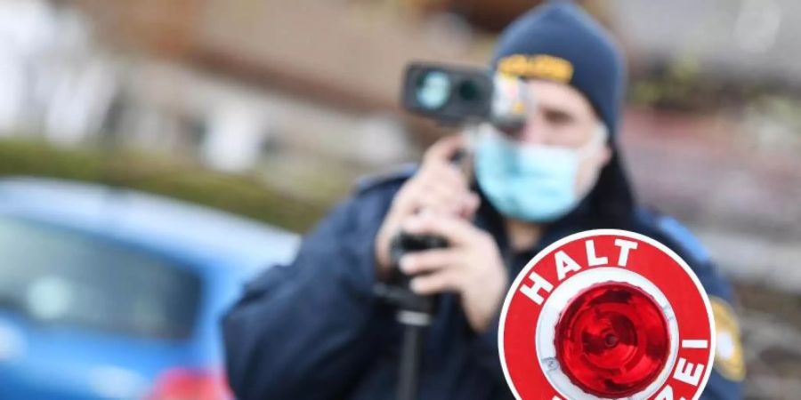 Polizisten blitzen Autofahrer. Höhere Bussgelder sollen Autofahrer dazu bringen, sich an Geschwindigkeitsbegrenzungen zu halten. Foto: Angelika Warmuth/dpa