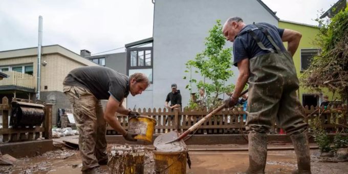 Mit Eimern entsorgen Anwohner die Schlammmassen nach dem Hochwasser der Kyll. Zahlreiche Häuser im Ort waren betroffen, Bewohner mussten evakuiert werden. Foto: Harald Tittel/dpa Mit Eimern entsorgen Anwohner die Schlammmassen nach dem Hochwasser der Kyll. Zahlreiche Häuser im Ort waren betroffen, Bewohner mussten evakuiert werden. Foto: Harald Tittel/dpa