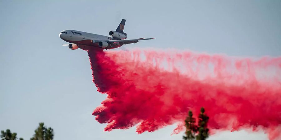 Ein DC-10 Tankflugzeug wirft Löschmittel ab, um die Ausbreitung des Salt Fire in der Nähe von Lakehead im Shasta County zu begrenzen. In Kalifornien verschärfte heisses und trockenes Wetter die Feuerlage. Im Norden brannten drei grössere Feuer, die Tausende Menschen zeitweise in die Flucht schlugen. Foto: Noah Berger/AP/dpa